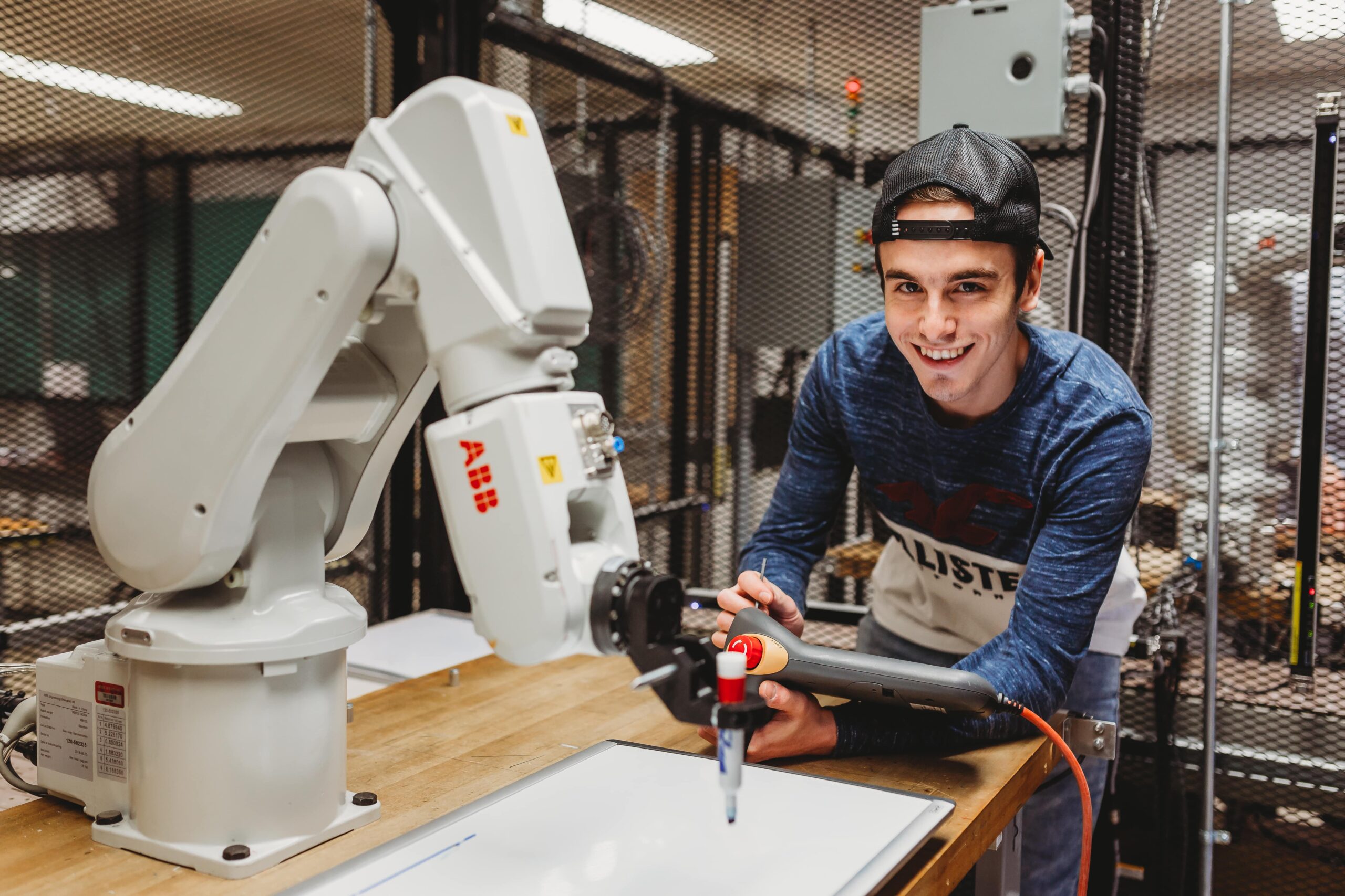 Étudiant manipulant un bras robotisé.