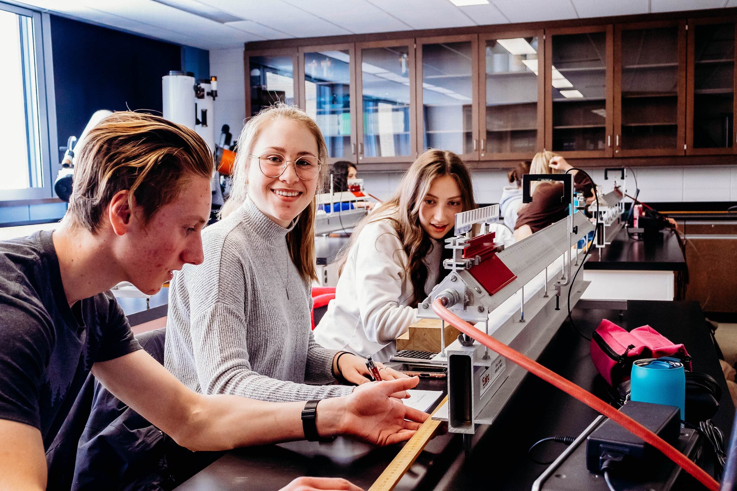 Étudiante souriant à la caméra dans une classe.