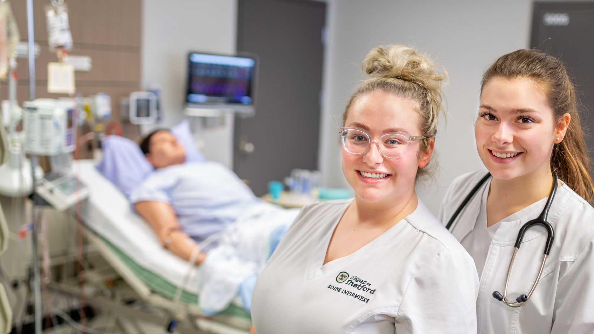 Deux étudiantes en soins infirmiers souriant à la caméra.