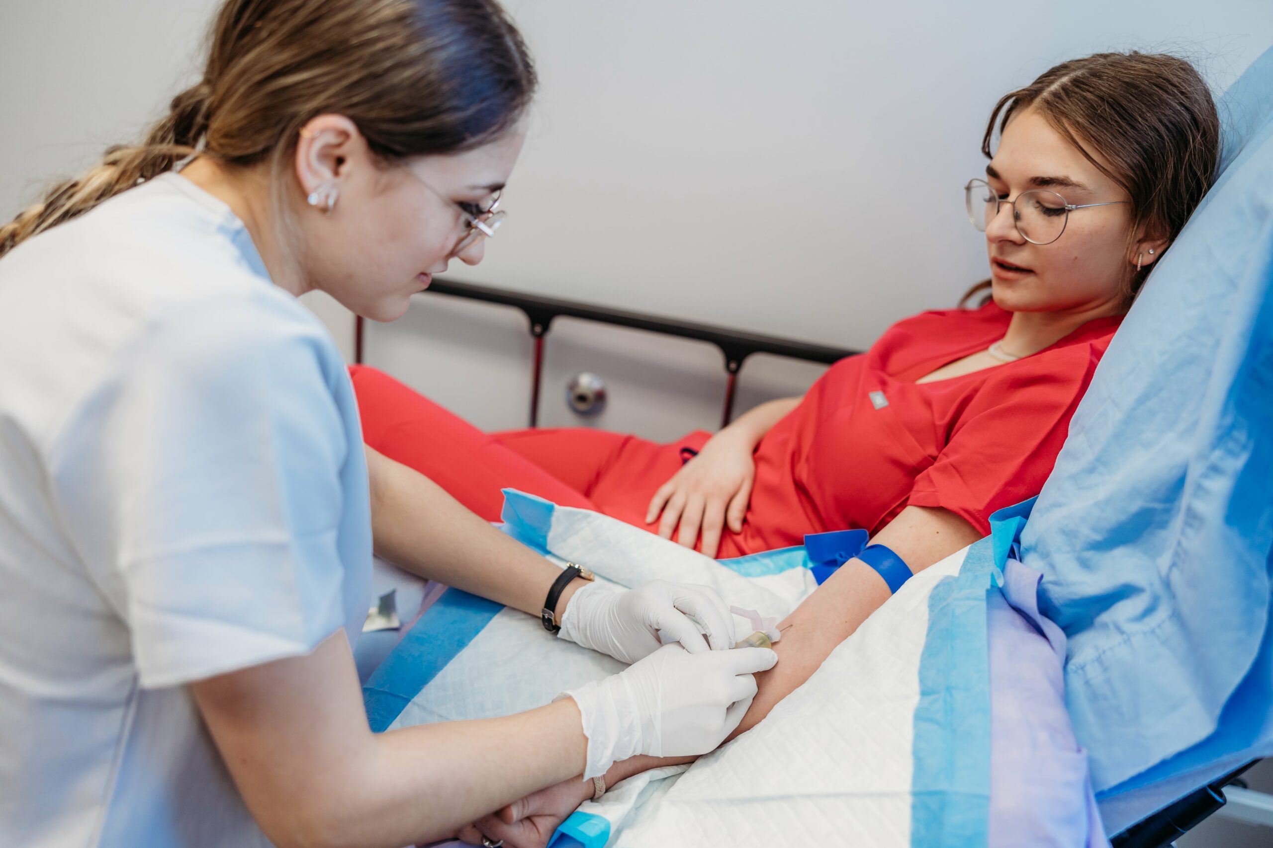 Deux étudiantes en soins infirmiers simulent des procédures médicales. L'une est sur une civière.