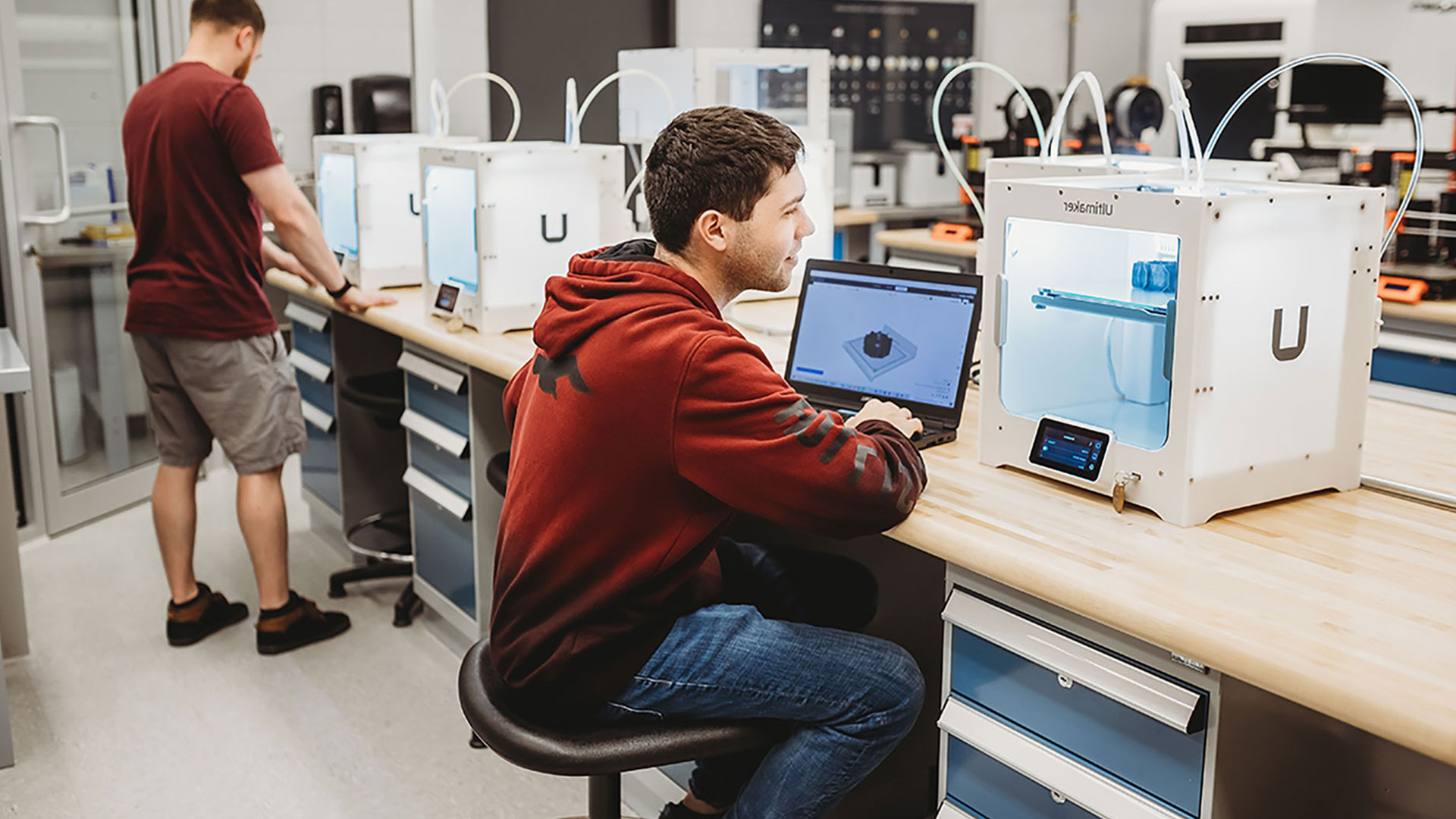 Un étudiant travaillant avec une imprimante 3D.