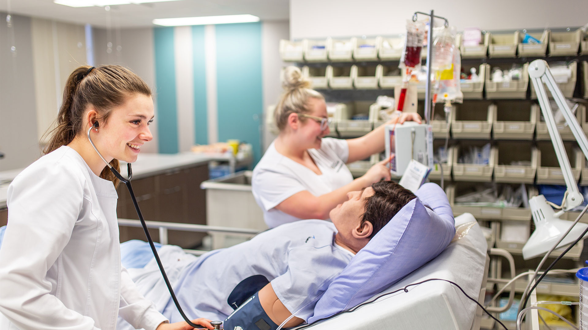 Étudiantes en soins infirmiers dans un contexte de simulation avec mannequin.