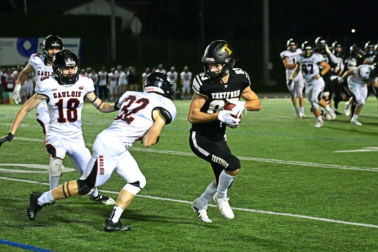 Joueur de football collégiale en plein action avec l'uniforme des Filons du Cégep de Thetford.