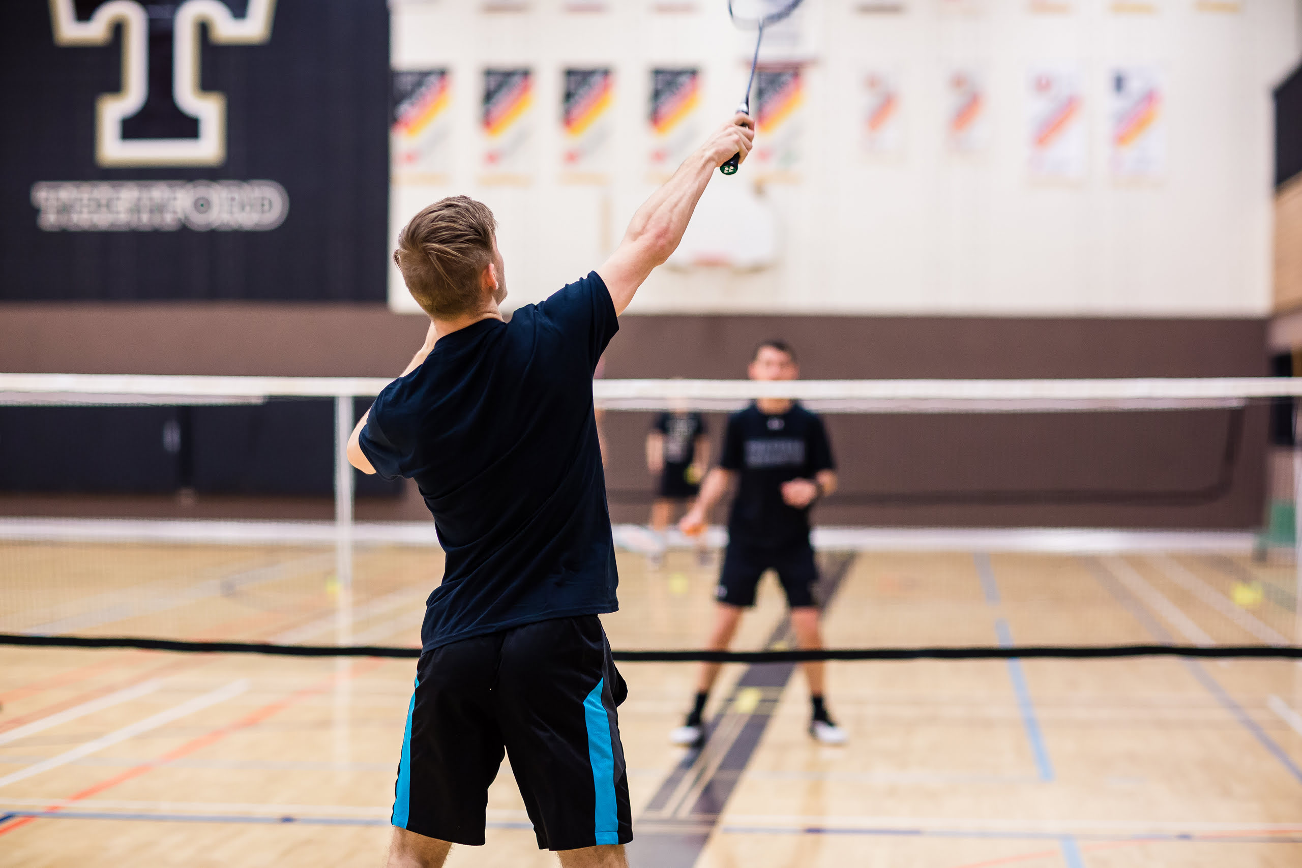 Un joueur de badminton fait un smash.
