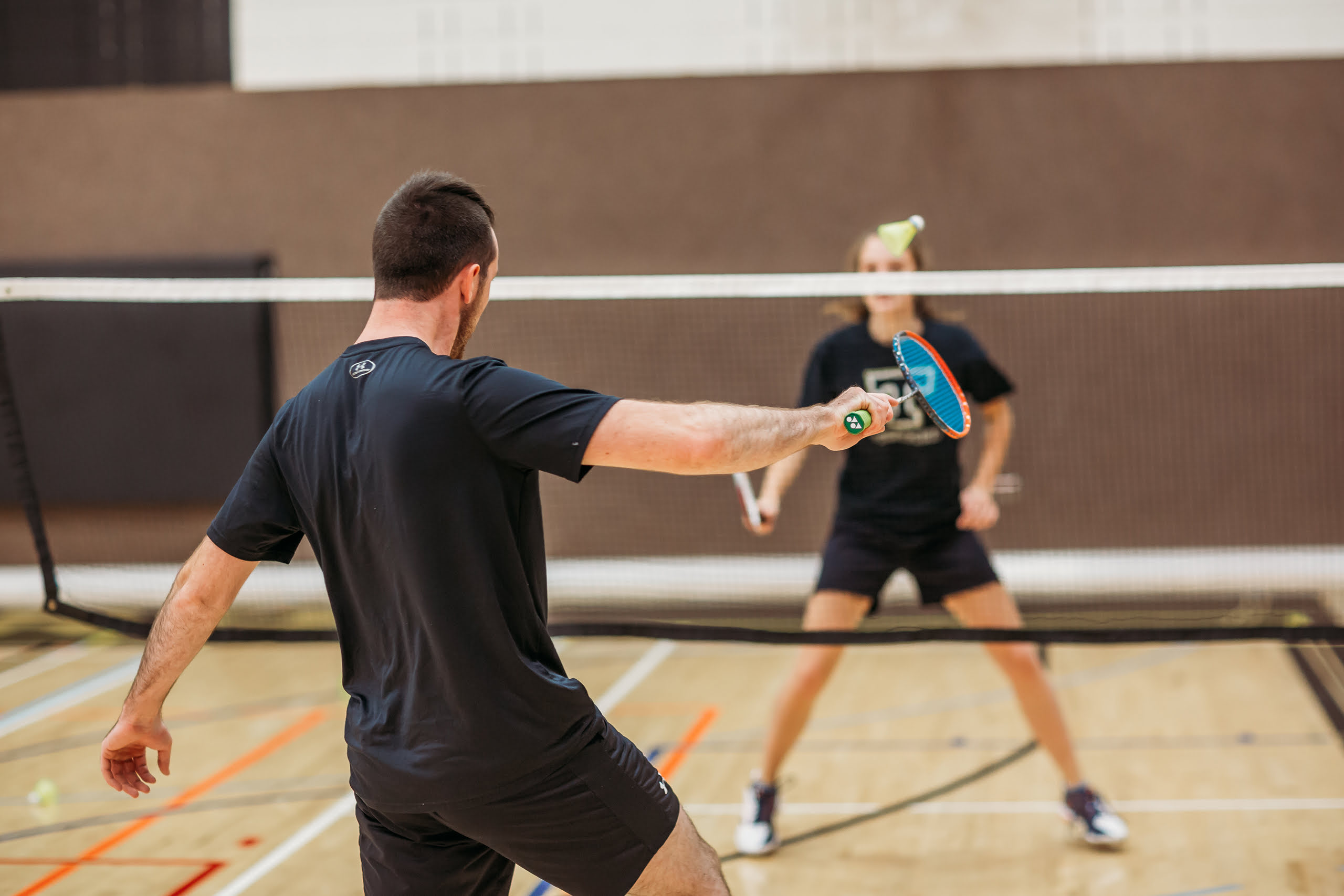 Un joueur de badminton se prépare à recevoir le volant.