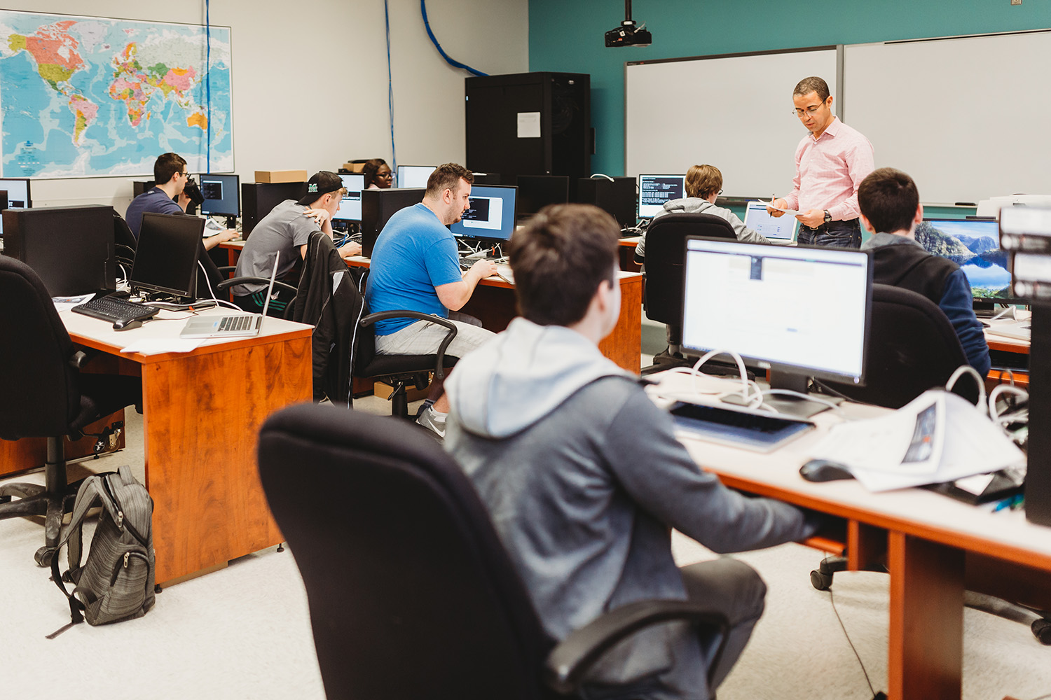 Des étudiants dans une salle de postes informatiques.