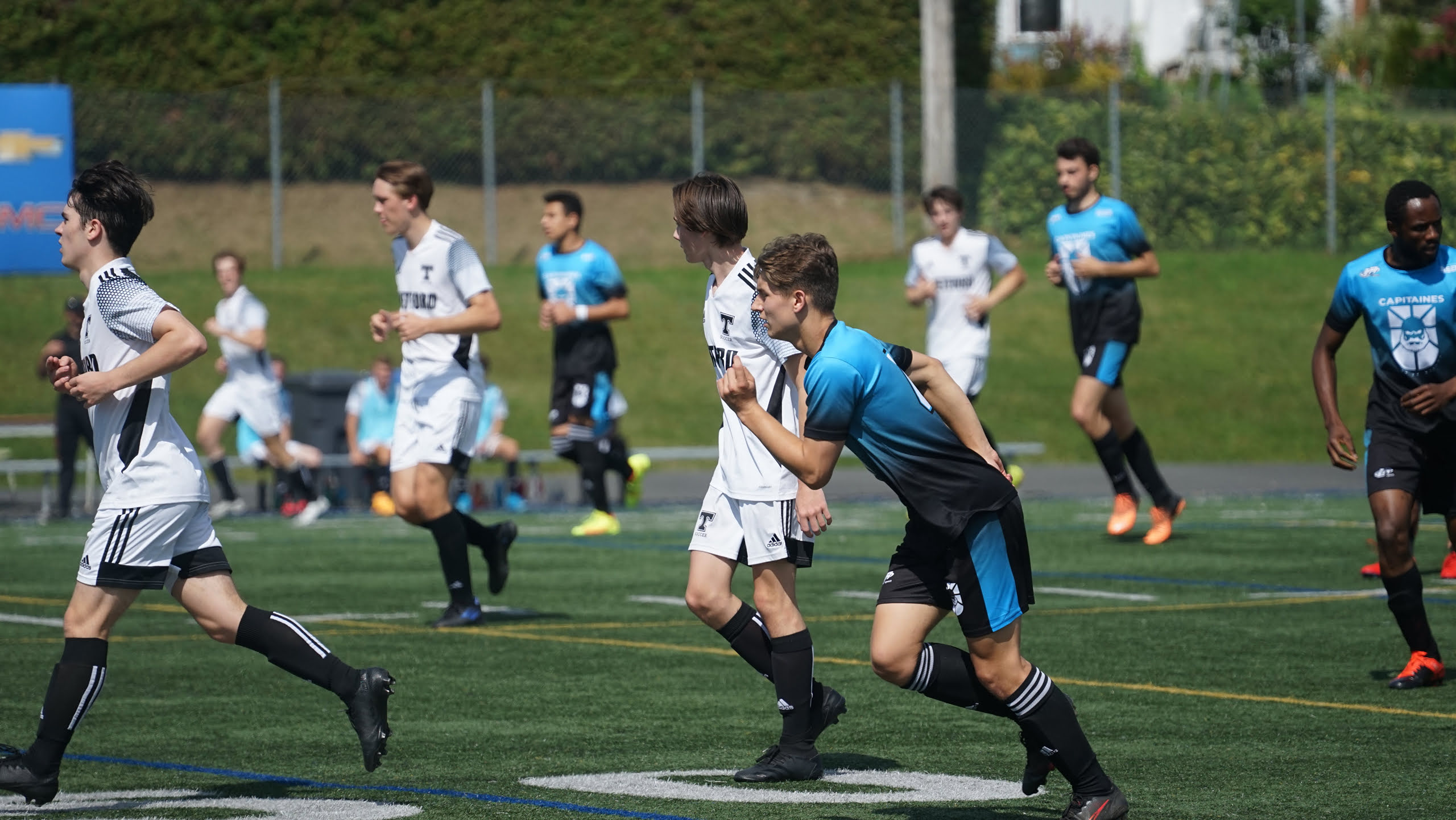 Les joueurs de l'équipe de soccer masculin D2 sont en mouvement sur le terrain.